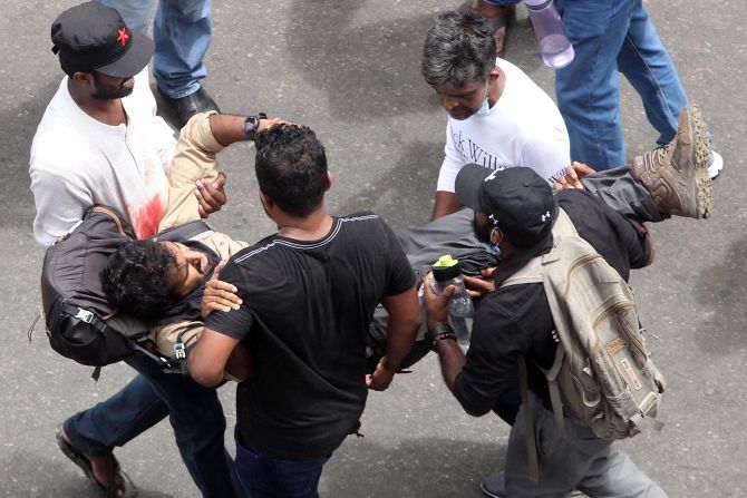 Protesters carry an injured man on Saturday.