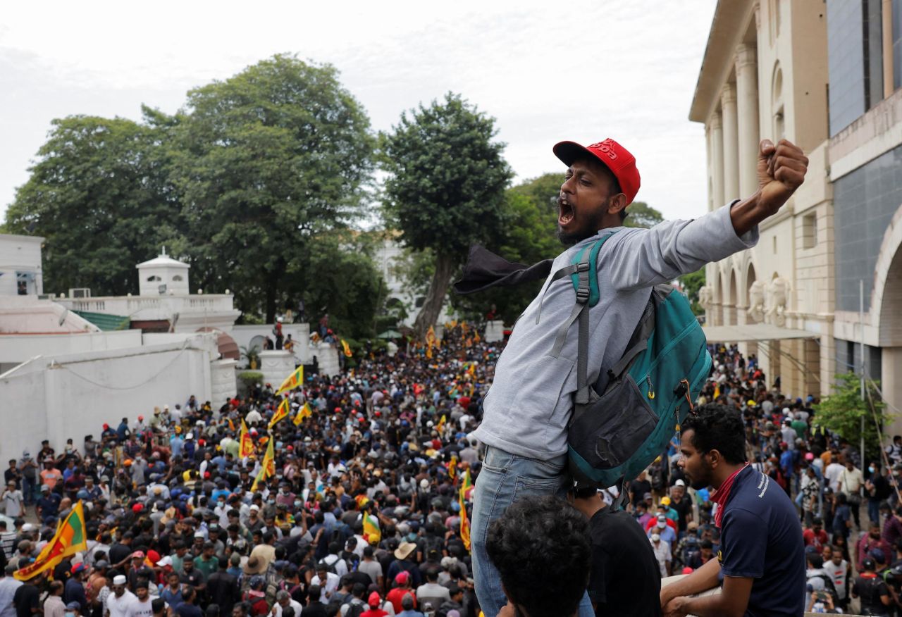 A protester stands above the crowd at the President's House on Saturday.