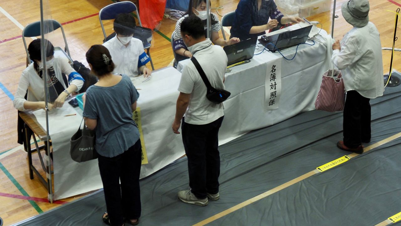 Voters receive their ballots during Japan's upper house elections at a polling station in Tokyo on July 10.