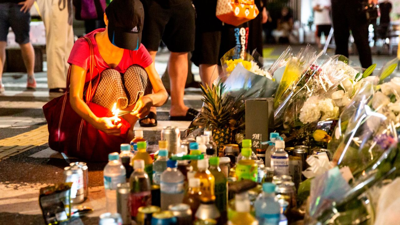 A woman lights joss sticks at a site outside of Yamato-Saidaiji Station, near where Shinzo Abe was shot.