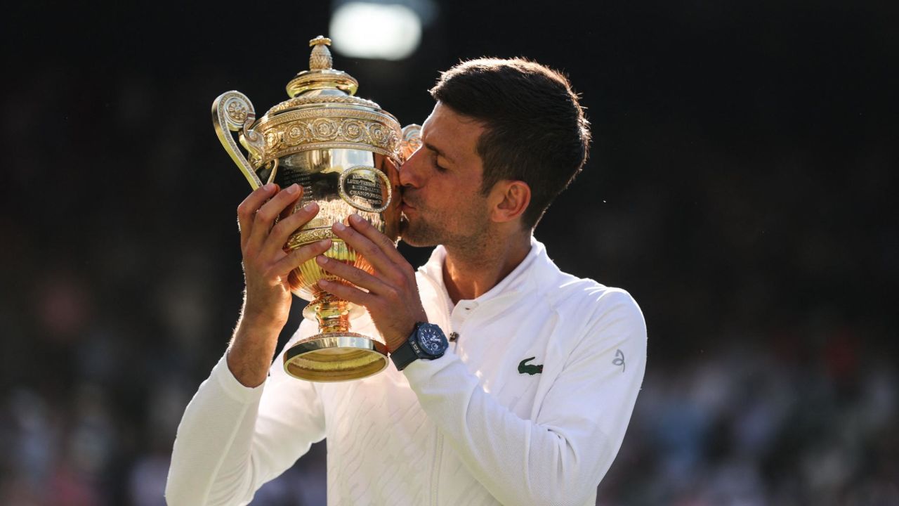 Novak Djokovic kisses the trophy after defeating Australia's Nick Kyrgios in the men's singles final at Wimbledon.