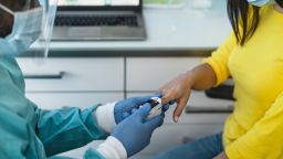 Medical worker examining oxygenation to female patient with new oximeter device during corona virus outbreak