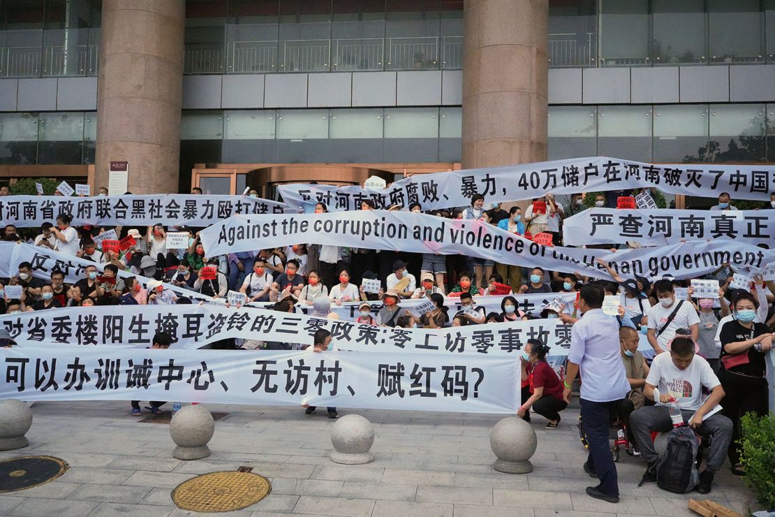 A banner in Chinese reads: "400,000 depositors dashed their Chinese dream in Henan."