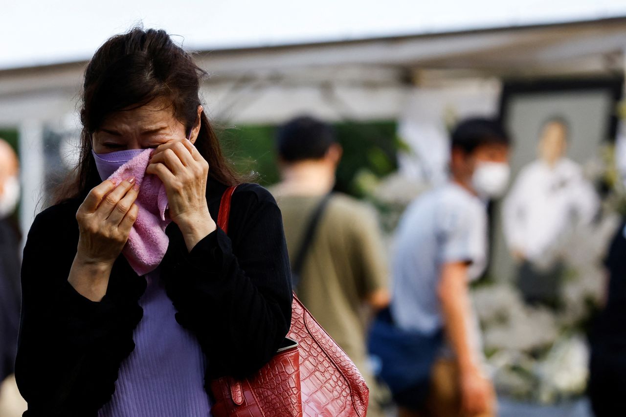 A mourner cries near a flower offering at Zojoji Temple, in Tokyo, Japan, on July 11.