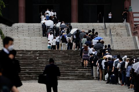 Mourners stand in line to pay tribute to late former Prime Minister Shinzo Abe at the Zojoji temple in Tokyo, Japan, on Tuesday, July 12, 2022. 