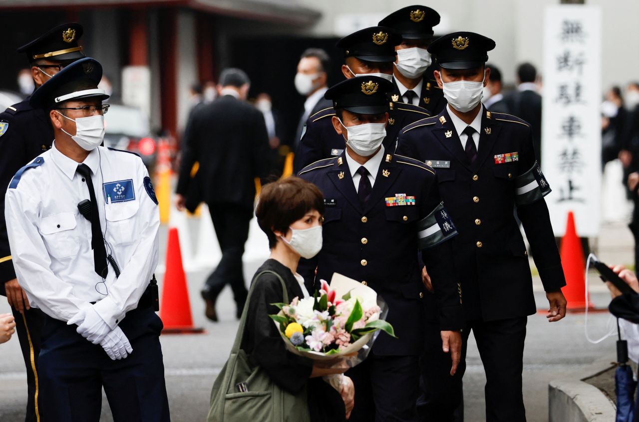 Honor guards from the Japan Self-Defense Forces, officials and mourners walk towards the Zojoji temple, Tuesday.