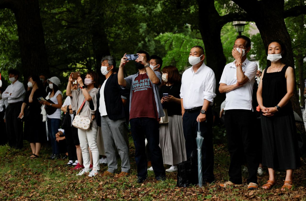 People stand outside the Zojoji temple in Tokyo Tuesday.