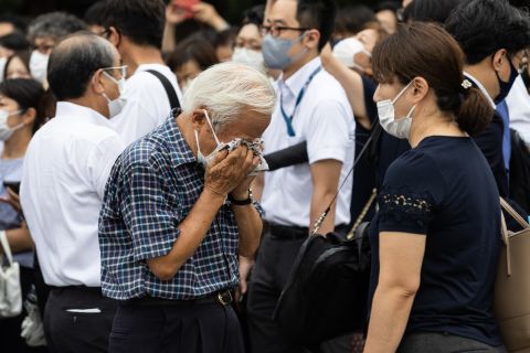 A man covers his face as he pays his respects for Abe.