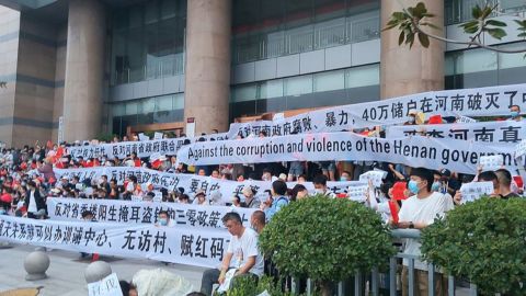 Over 3,000 Chinese demonstrators hold banners during a rare mass protest over the freezing of deposits by rural-based banks, outside a People's Bank of China building in Zhengzhou, Henan province, China July 10, 2022. 