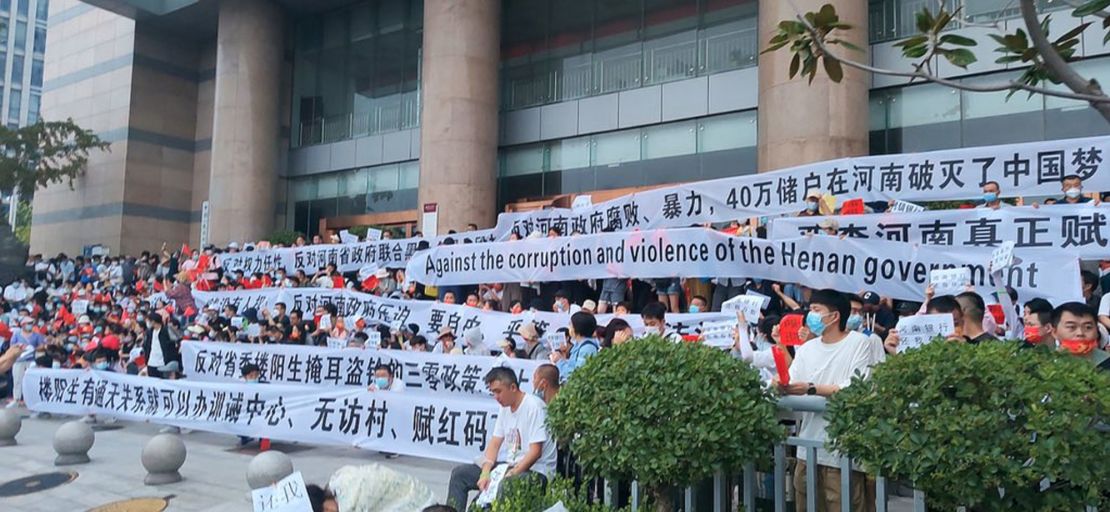 Over 3,000 Chinese demonstrators hold banners during a rare mass protest over the freezing of deposits by rural-based banks, outside a People's Bank of China building in Zhengzhou, Henan province, China July 10, 2022. 
