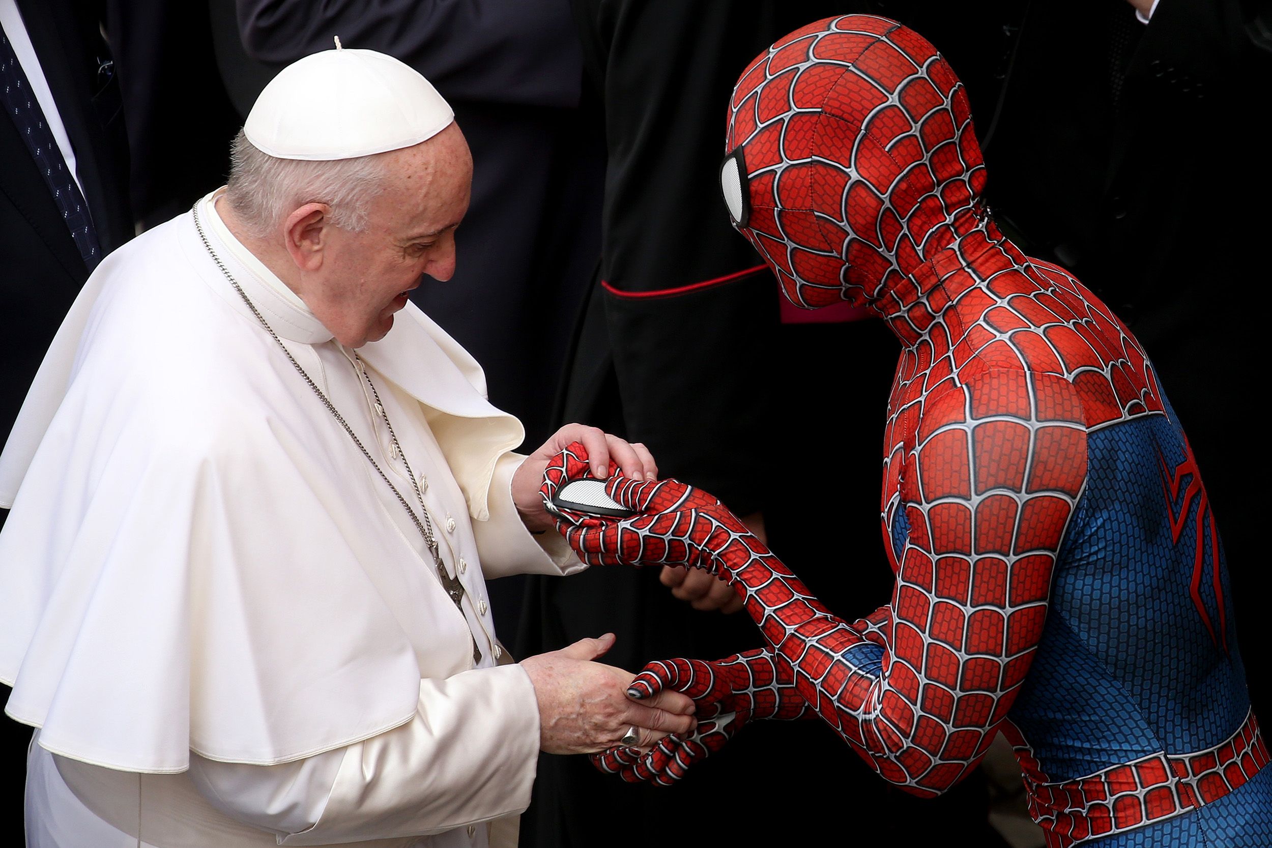 Francis shakes hands with a man dressed as Spider-Man while visiting with people at the Vatican in June 2021.