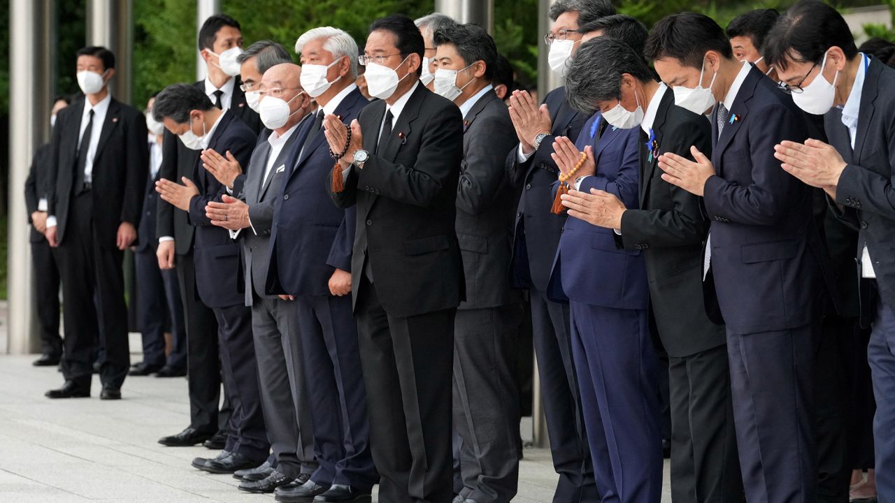 Japan's Prime Minister Fumio Kishida, officials and employees offer prayers outside the Prime Minister's Office in Tokyo on July 12.