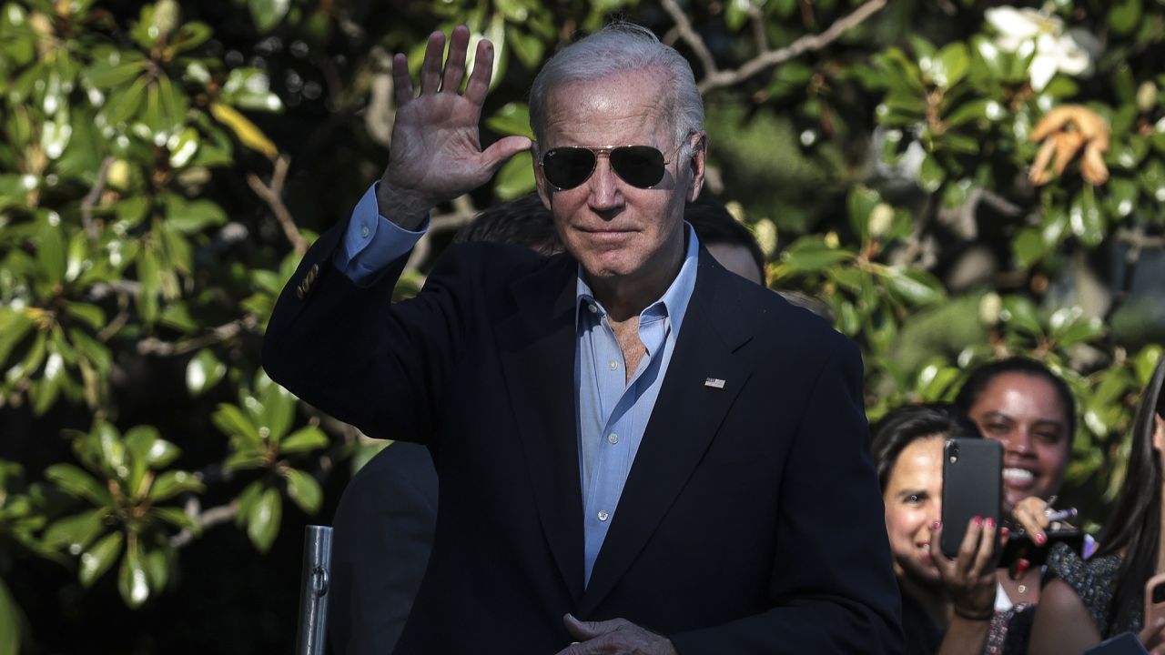 US President Joe Biden waves while walking on the South Lawn of the White House after arriving on Marine One in Washington, DC on June 30. 