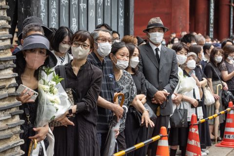 People wait for the hearse carrying the body of former Prime Minister Shinzo Abe in Tokyo, Japan, on July 12.