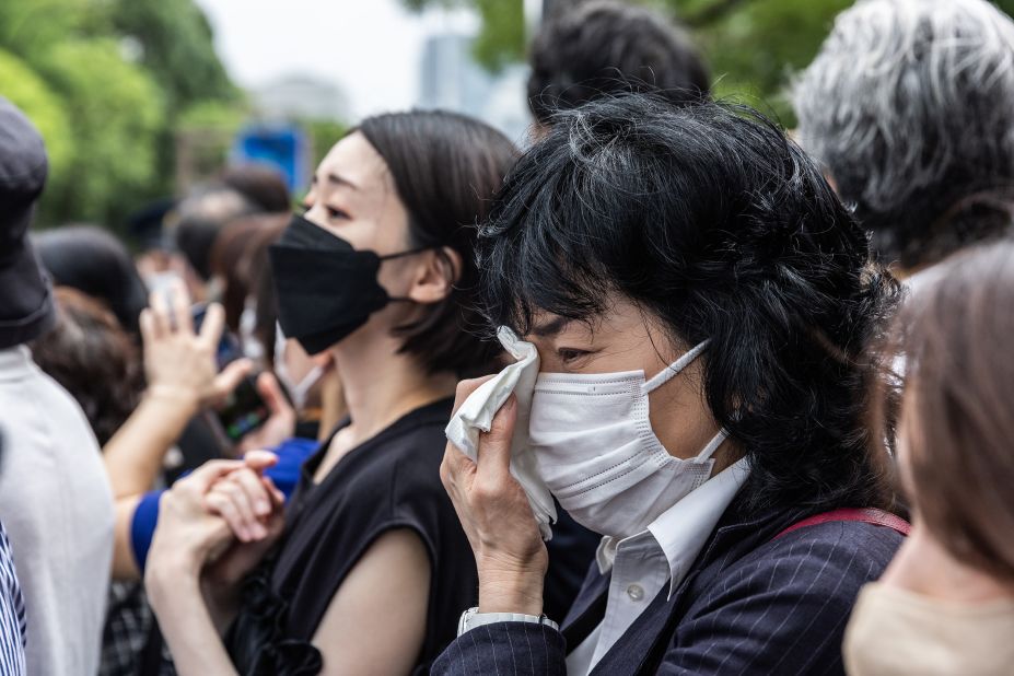 Mourners react after the hearse carrying the body of former Prime Minister Shinzo Abe drives by after his funeral in Tokyo, Japan, on July 12.