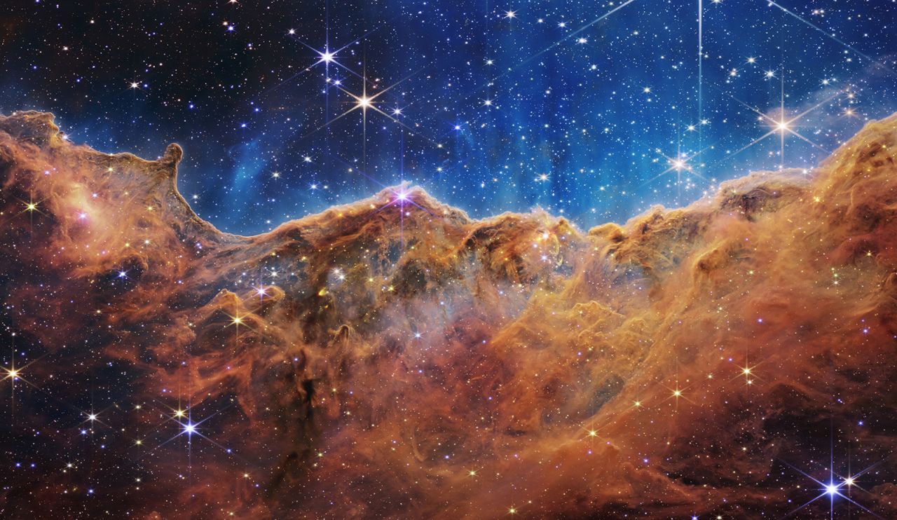 Webb's landscape-like view, called "Cosmic Cliffs," is actually the edge of a nearby, young, star-forming region called NGC 3324 in the Carina Nebula. The telescope's infrared view reveals previously invisible areas of star birth. 
