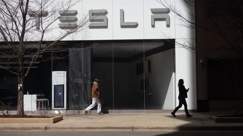 People walk past a downtown Tesla dealership on March 28, 2022 in Chicago, Illinois.