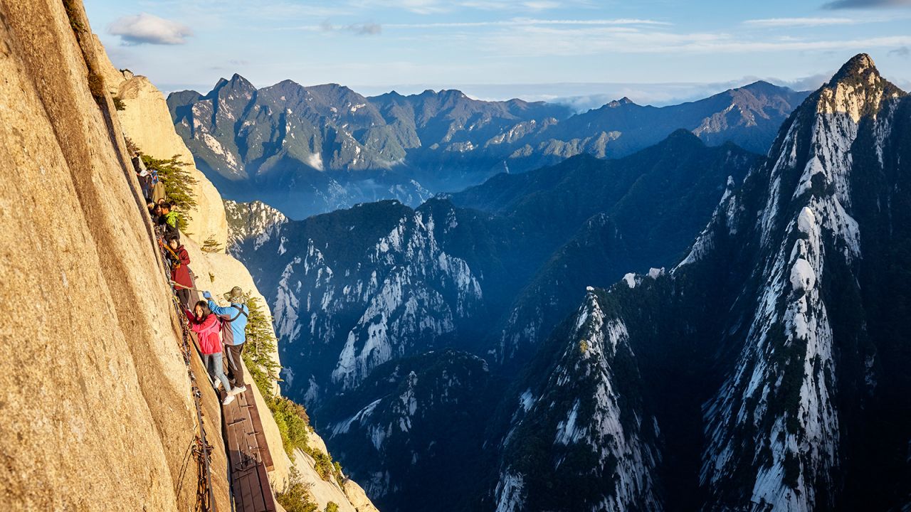 <strong>HuaShan, China:</strong> This epic trail to the South Peak of HuaShan is often billed as the most dangerous hike in the world. To reach the summit, hikers need to scale uneven steps and a series of ladders before hooking themselves onto a chain to traverse its renowned "plank walk."