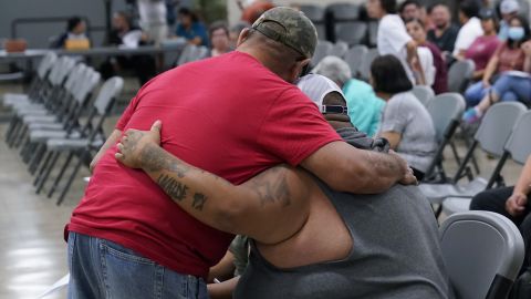 A family member of a shooting victim, who did not wish to share his name, is hugged by a friend during a city council meeting on July 12, 2022, in Uvalde, Texas. 