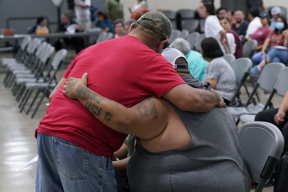 A family member of a shooting victim, who did not wish to share his name, is hugged by a friend during a city council meeting on July 12, 2022, in Uvalde, Texas.