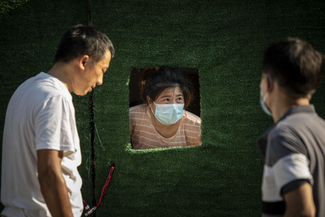 A Shanghai resident peeks through an opening in the barricade surrounding a neighborhood placed under Covid-19 lockdown on July 10.