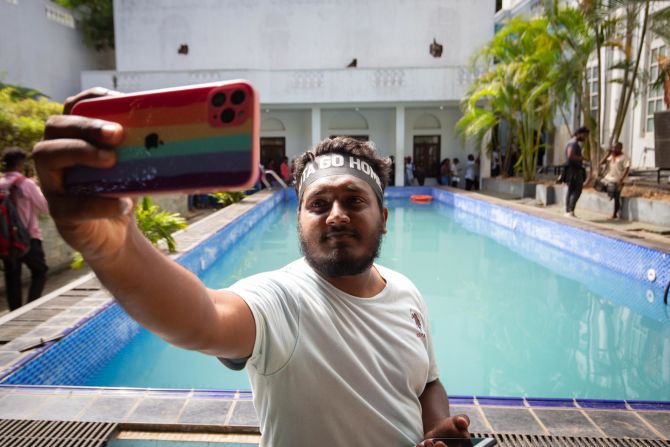 A protester takes a selfie near a swimming pool inside the presidential palace in Colombo on Wednesday. Protesters broke into that building over the weekend.