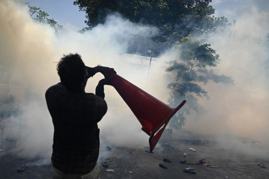 A man throws a cone amid tear gas on Wednesday.