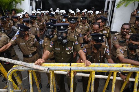 Members of the police stand guard in front of the police headquarters in Colombo during a protest on Monday.