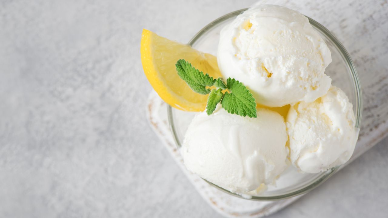 Homemade lemon ice cream, served with a lemon wedge and mint garnish.