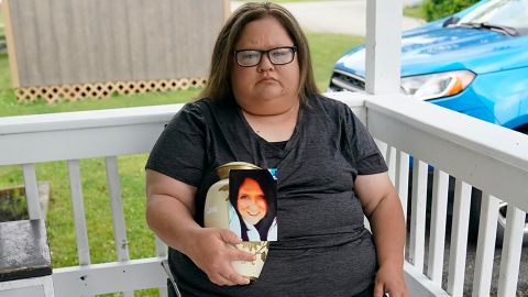 Kelly Titchenell holds a photo of her mother, Diania Kronk, and an urn containing her mother's ashes.