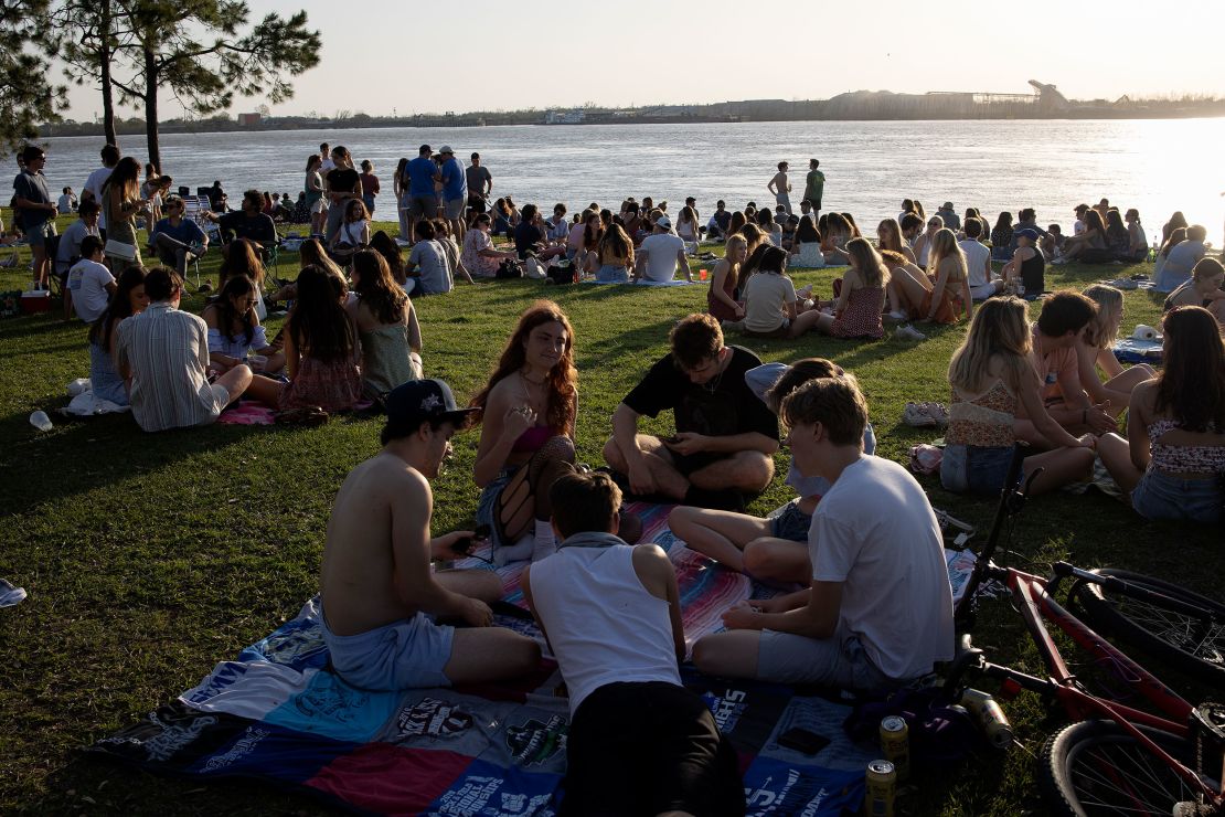 Meeting outdoors is "much safer" than indoors when it comes to risk of Covid-19 infection, CNN Medical Analyst Dr. Leana Wen said. College students socialize on March 18 in New Orleans. 