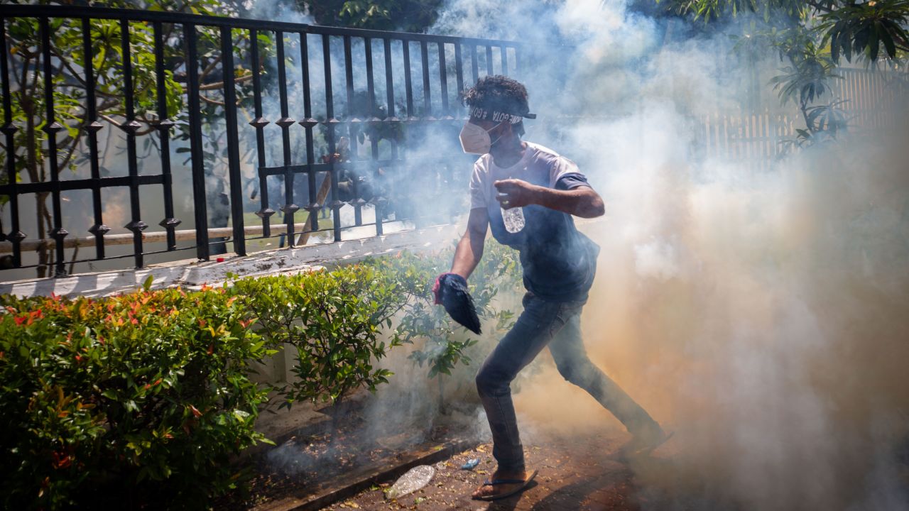A protester runs for cover from a tear gas canister during a protest in Colombo, Sri Lanka, on July 13.