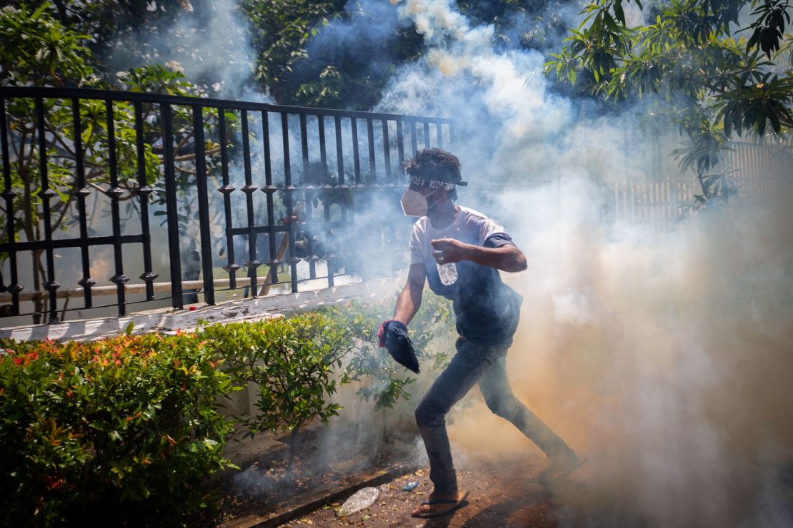 A protester runs for cover from a tear gas canister during a protest in Colombo, Sri Lanka, on July 13. 