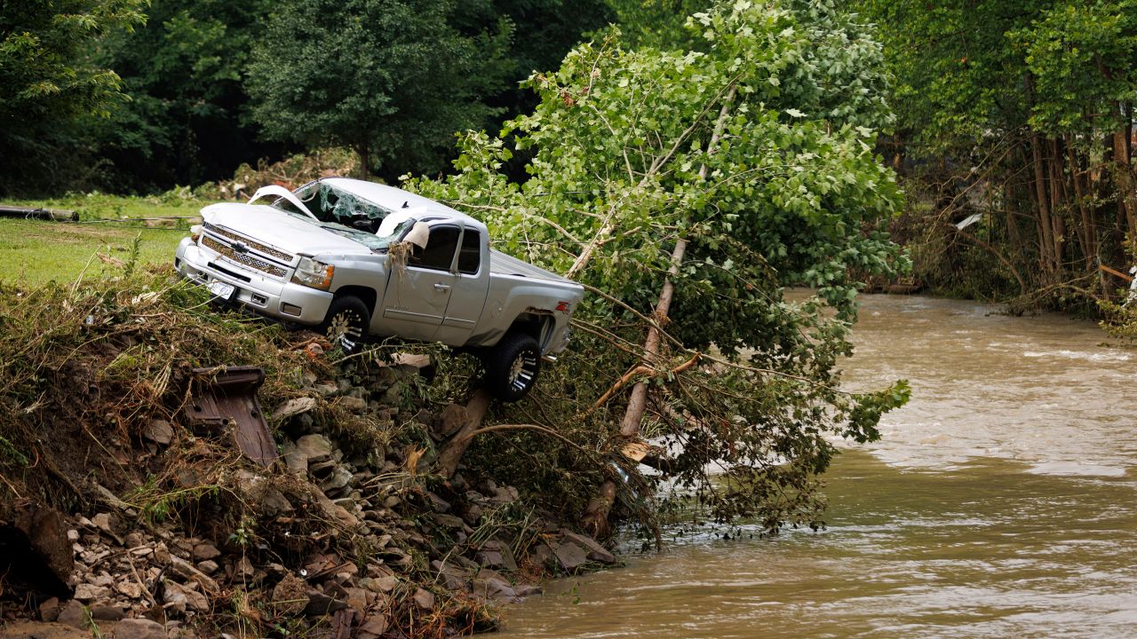 A truck sits on the edge of a river, Thursday, July 14, 2022, in Whitewood, Virginia, after being swept away in a flash flood.