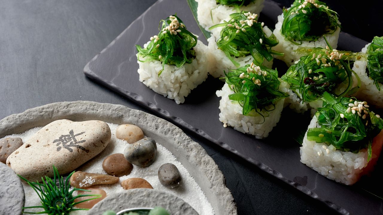 Sushi rolls are wrapped in papery sheets called nori. Here, wakame garnishes the top of sushi rolls.