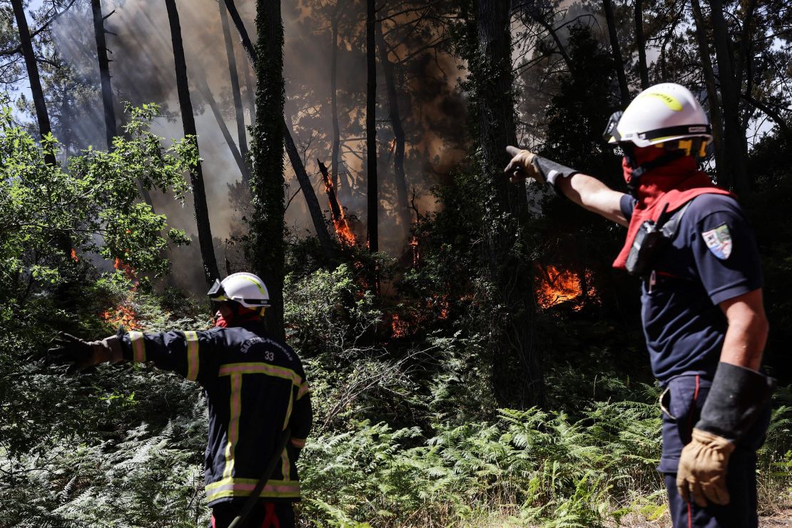 Firefighters work to extinguish a wildfire which broke out at the bottom of the Dune du Pilat near Teste-de-Buch, southwestern France on July 13.