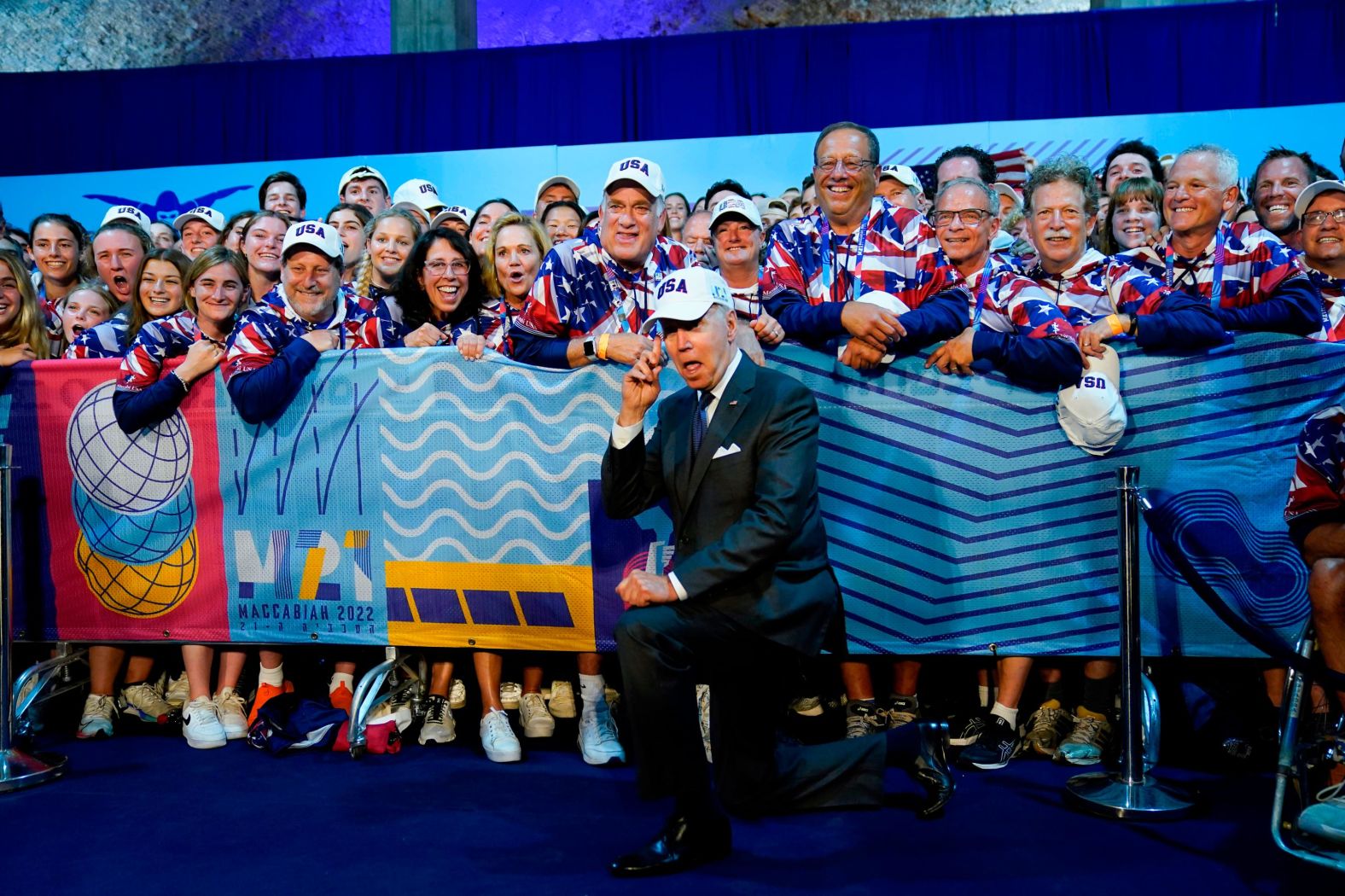 Biden points to his USA hat as he meets with US athletes competing in the Maccabiah Games, an international Jewish and Israeli multi-sport event, on Thursday. Biden also watched a portion of the opening ceremonies.