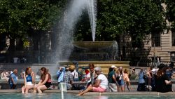 People cool off beside the fountains in Trafalgar Square in central London on June 17, 2022, on what is expected to be the hottest day of the year so far in the capital. - A Level 3 Heat-Health alert for London, the East of England and the South East has been announced to help protect health services, the UK Health Security Agency (UKHSA) has said, Friday.