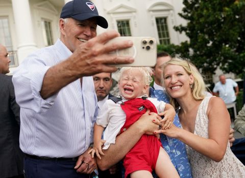 A child cries as US President Joe Biden takes a selfie with people attending the Congressional Picnic at the White House on Tuesday, July 12.