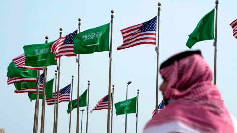 A man stands under American and Saudi Arabian flags before a visit by US President Joe Biden, at a square in Jeddah, Saudi Arabia, on July 14, 2022.
