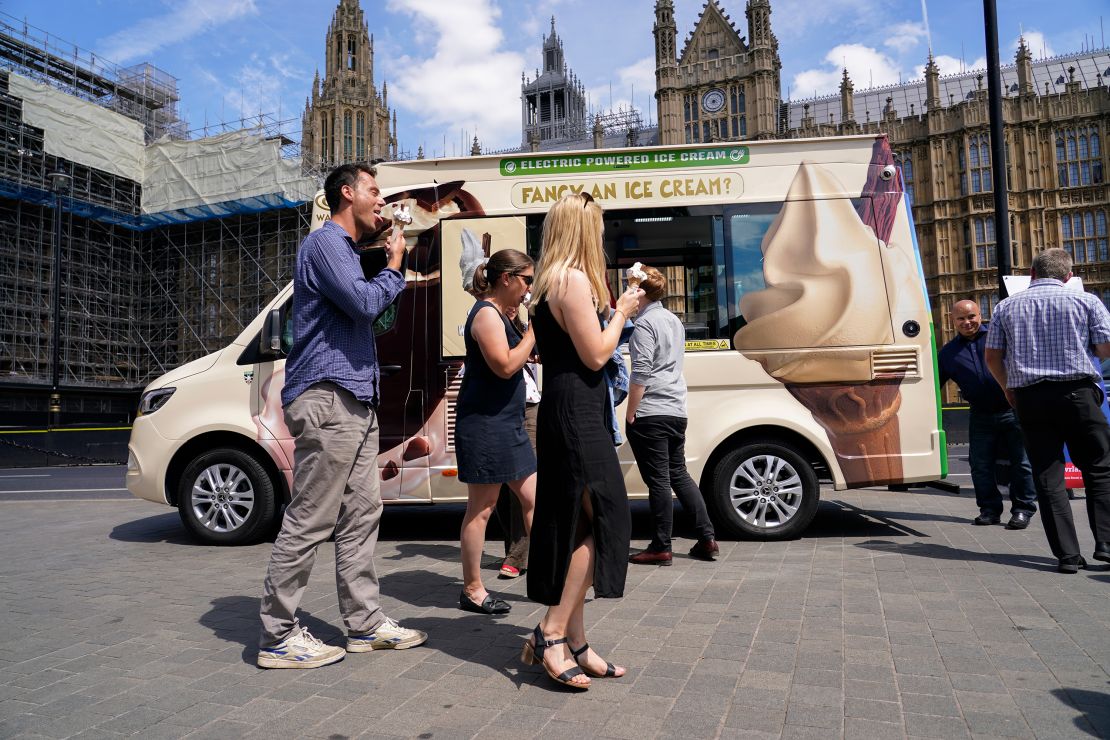 People eat ice cream outside the houses of Parliament in London on Wednesday.