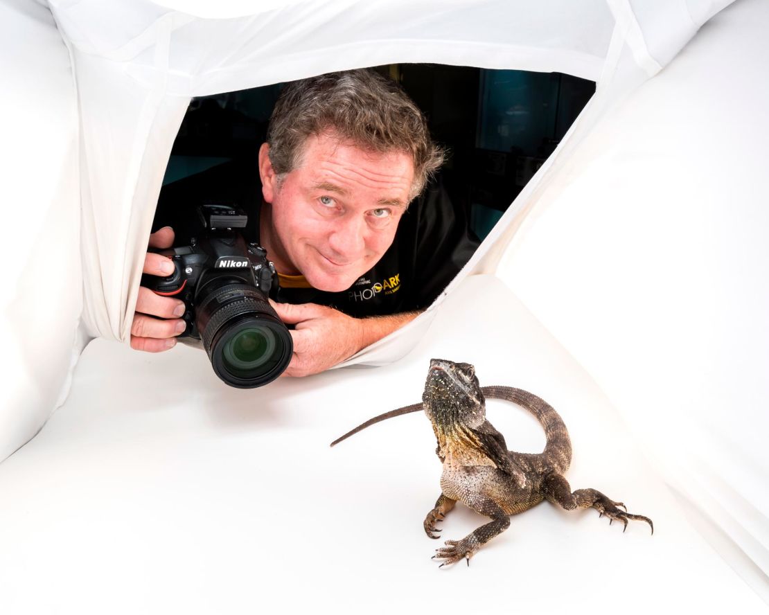 Joel Sartore pictured photographing a frill necked lizard in Australia.