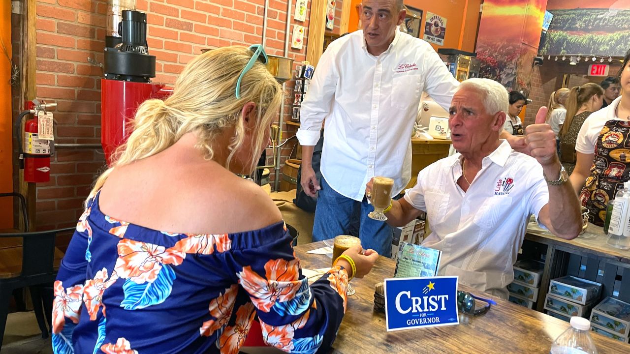 Crist reacts after trying an iced coffee drink at La Colada Gourmet in Miami on July, 9, 2022.