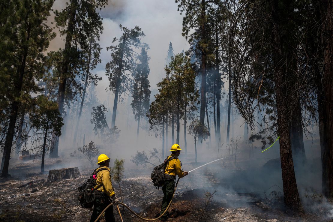 Firefighters put out hot spots from the Washburn Fire in Yosemite National Park earlier this week. The climate crisis has intensified deadly, costly wildfires in the West.