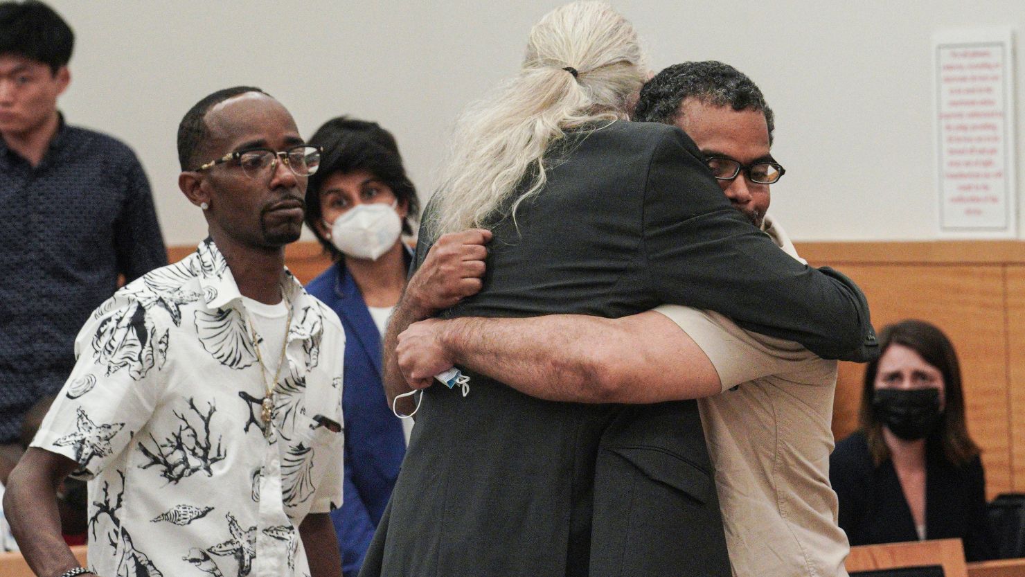 Vincent Ellerbe, left, approaches as Thomas Malik, right, embraces his lawyer Ron Kuby, center, following an exoneration hearing at Brooklyn Supreme Court on July 15, 2022, in New York.