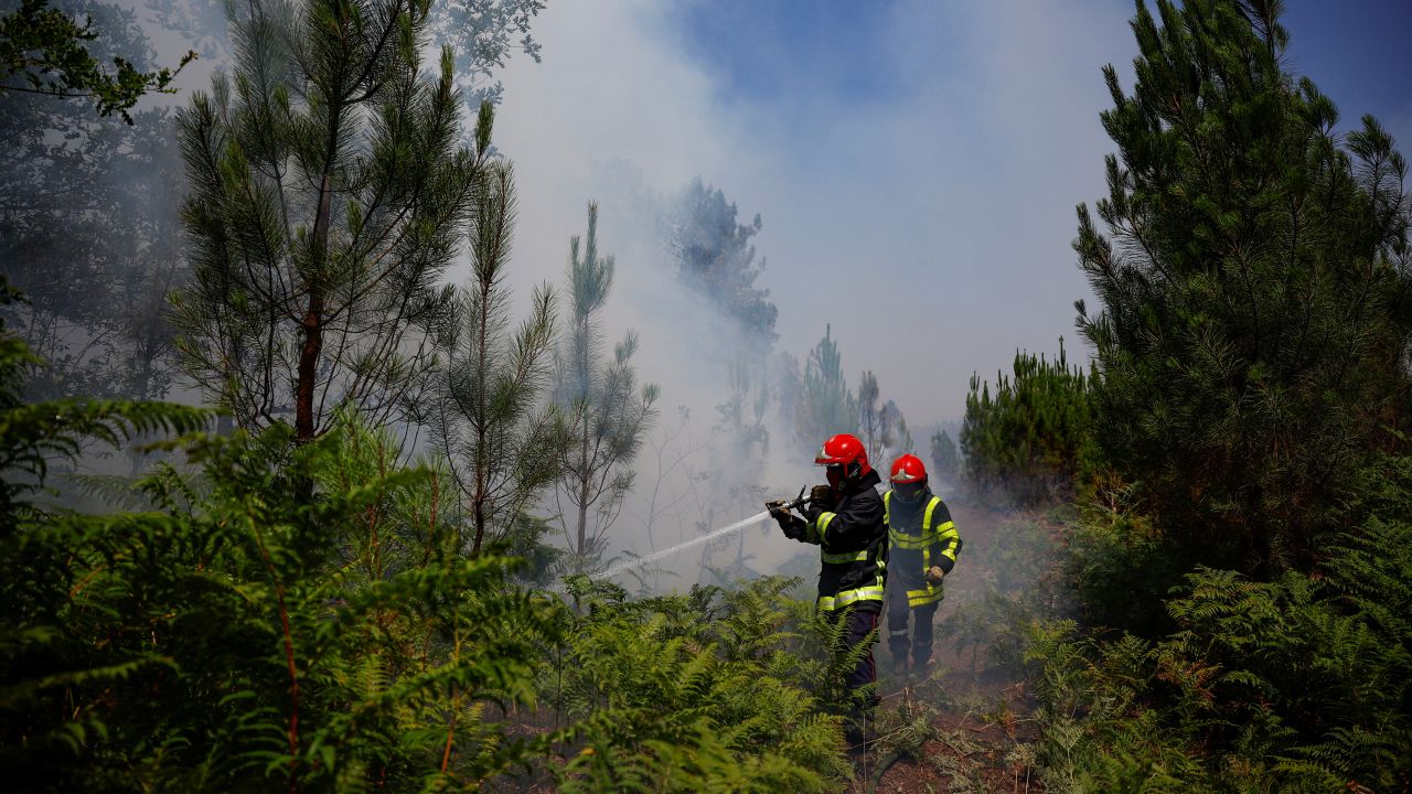 Firefighters work to contain a fire near Louchats, France, where the national weather agency issued an extreme heat alerts.