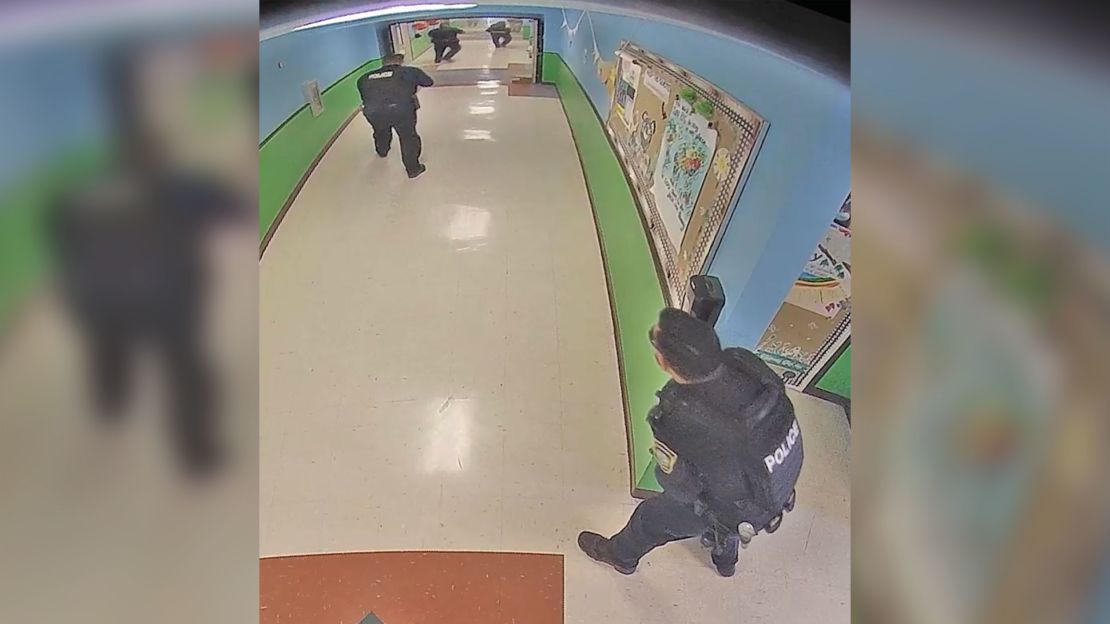 This photo released by the Texas House of Representatives Investigative Committee on the Robb Elementary Shooting, Uvalde Police officers enter from north end of a hallway inside the school.