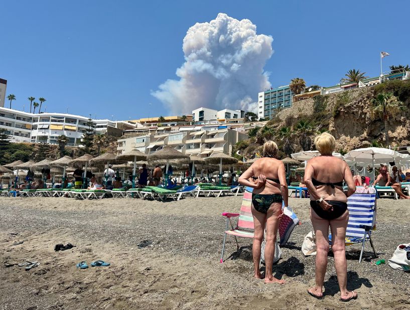 People look at plumes of smoke caused by a wildfire in Malaga, Spain, on July 15.