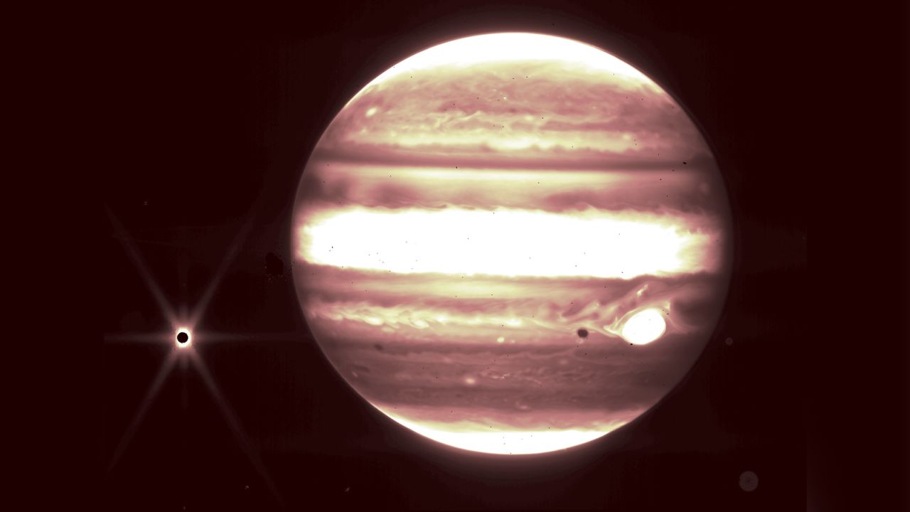 Jupiter, center, and its moon Europa, left, are seen through the Webb telescope's NIRCam instrument.