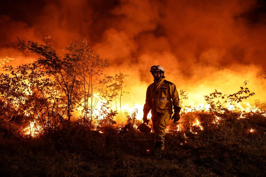 Firefighters set a backfire to a plot of land to prevent a wildfire from spreading further in Louchats, France, on July 17.